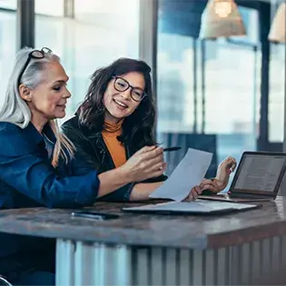 Women working on their devices in an office min